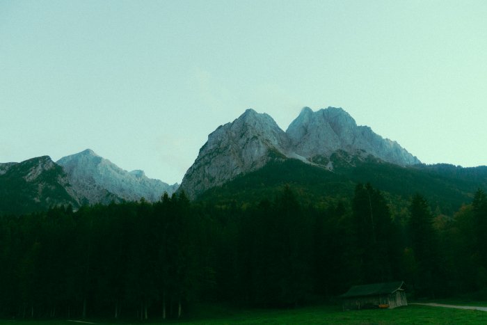 Mountain range with forest and a small cabin
