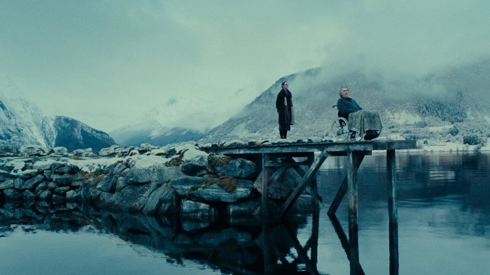 Two people on a pier in a snowy landscape