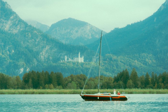 Sailboat on a lake with a castle in the mountains