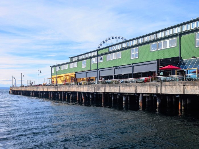 Pier with green building and Ferris wheel