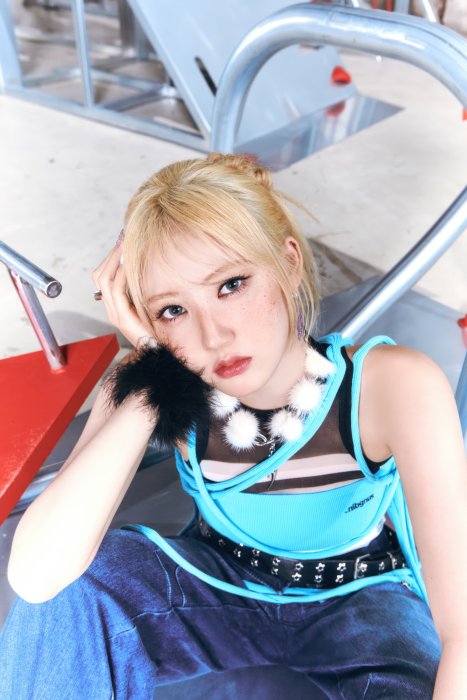 Woman with blonde hair and blue top posing