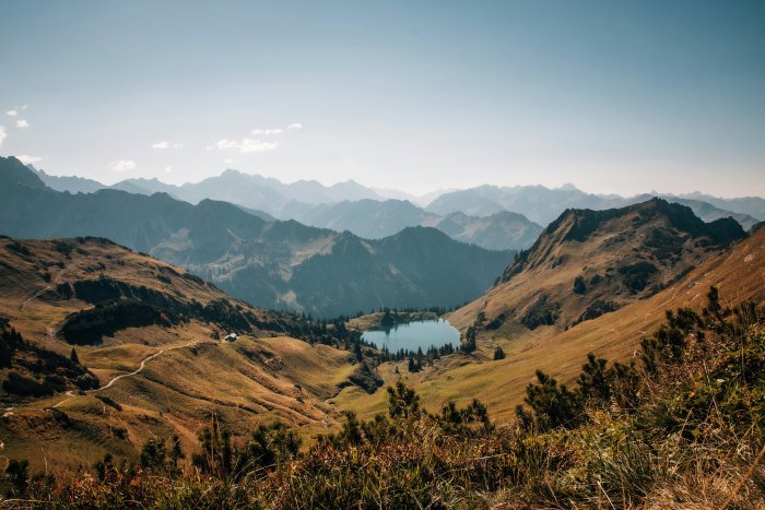 Alpine lake surrounded by mountains and rolling hills