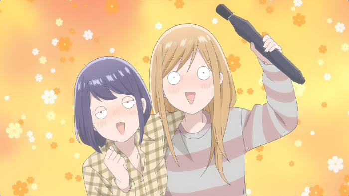 Two anime girls with surprised expressions holding a black object