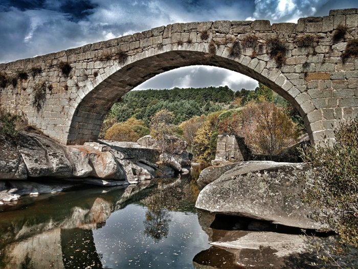 Stone bridge over a river with autumn foliage