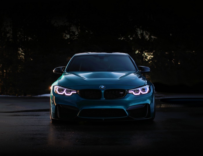 Blue BMW M3 parked at night