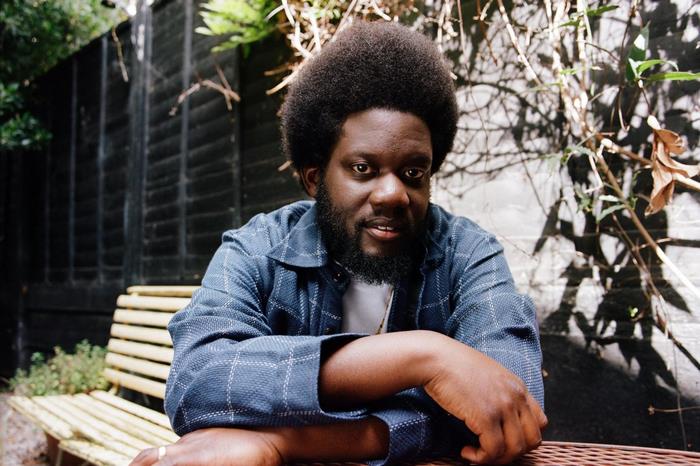 Michael Kiwanuka sitting outdoors