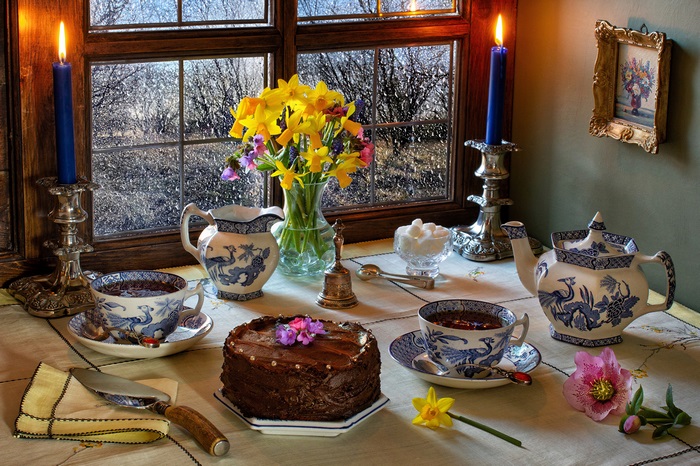 Chocolate cake and tea set by a rainy window