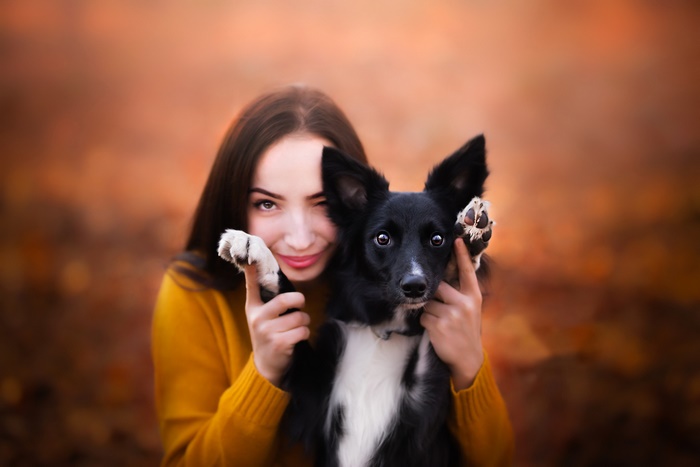 Woman and dog with paws over ears