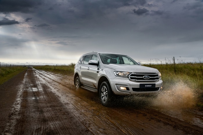 Silver Ford Everest SUV driving on a muddy road