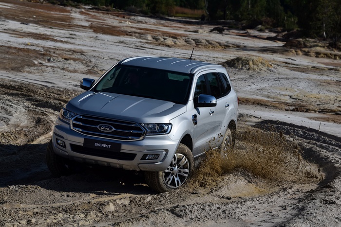 Silver Ford Everest SUV driving through mud