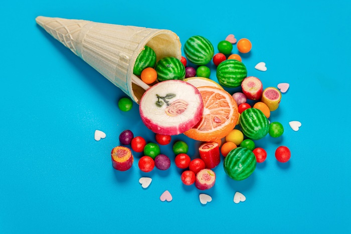 Ice cream cone spilling candies and lollipops