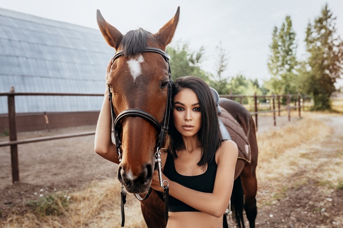 Woman with black hair and a brown horse