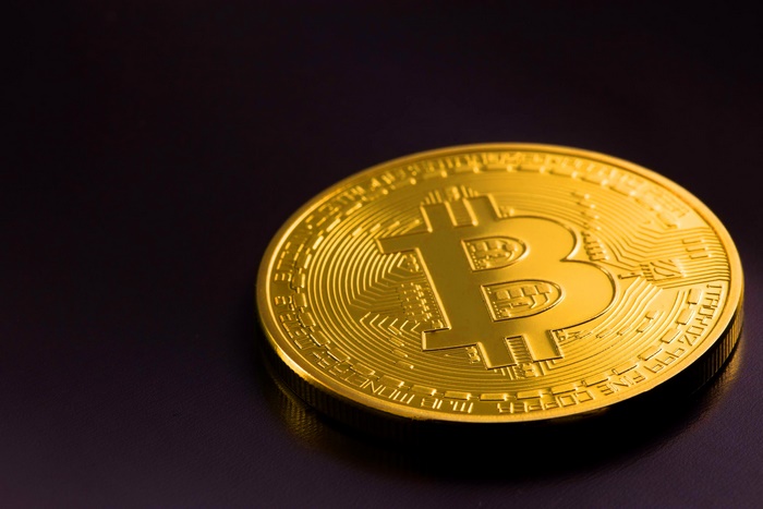 Gold Bitcoin coin on a dark surface
