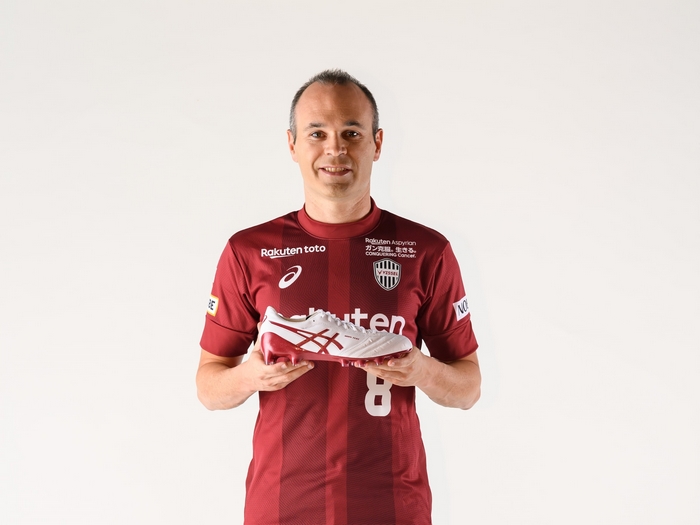 Andrés Iniesta holding ASICS soccer cleats