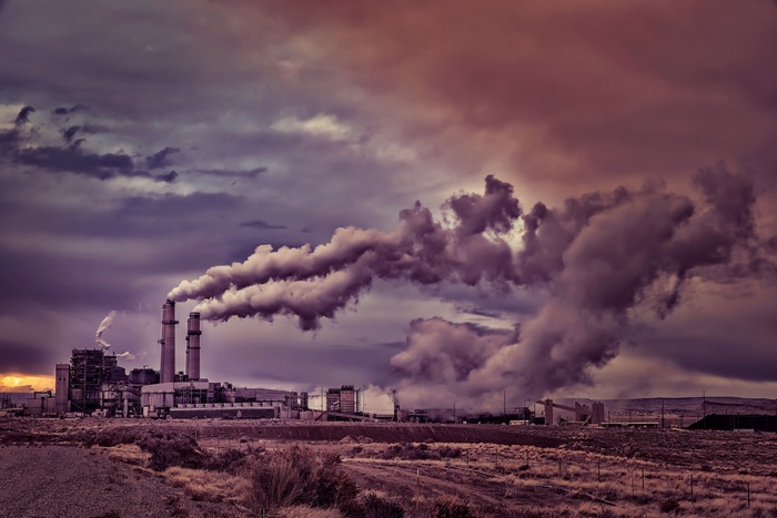 Factory with smoke stacks and dramatic clouds