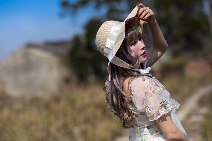 Woman in a straw hat with ribbons