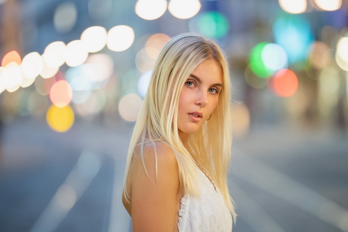 Blonde woman with blue eyes in bokeh background