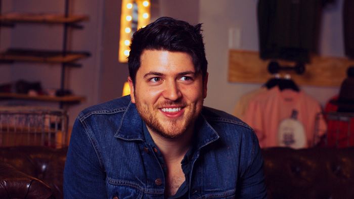 Olan Rogers smiling in a denim jacket