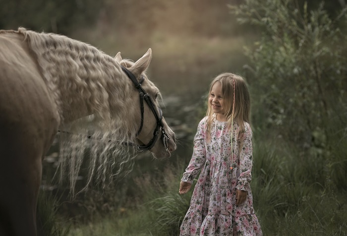 Girl in floral dress with blonde horse