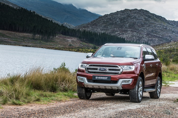 Red Ford Everest SUV parked by a lake