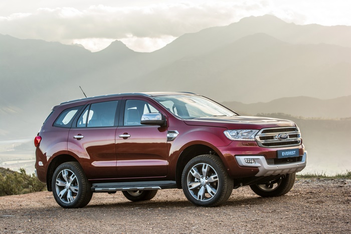 Red Ford Everest SUV parked on a dirt road with mountains
