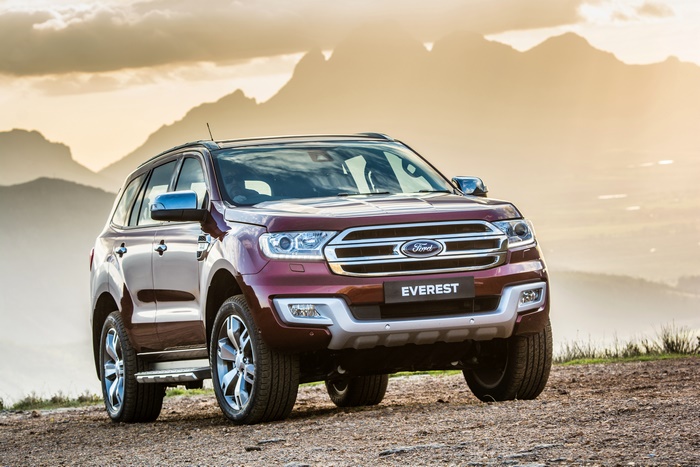 Red Ford Everest SUV parked on a dirt road with mountains in the background