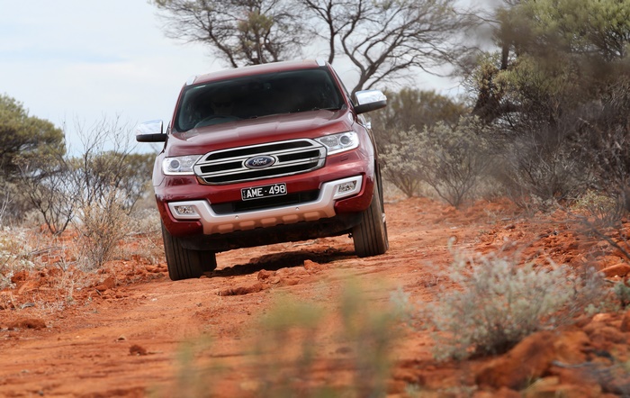 Red Ford Everest SUV driving on a dirt road