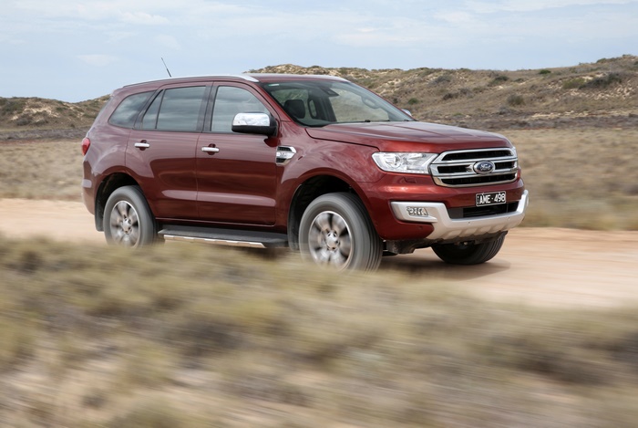 Red Ford Everest SUV driving on a dirt road