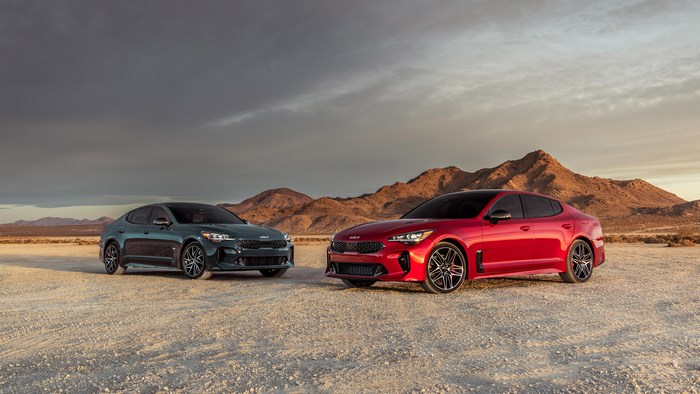 Two Kia Stinger cars in a desert landscape