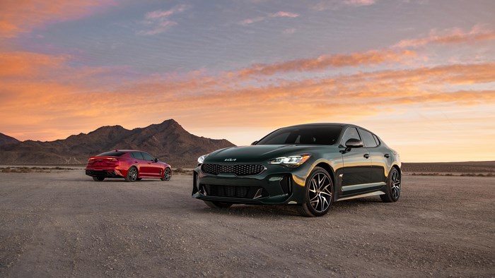 Green and red Kia Stinger cars in desert landscape