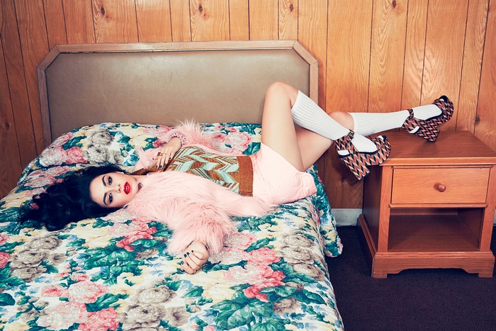Charli XCX lying on a bed