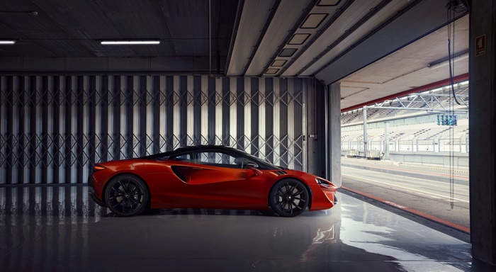 McLaren Artura 4K in a garage with a racetrack view