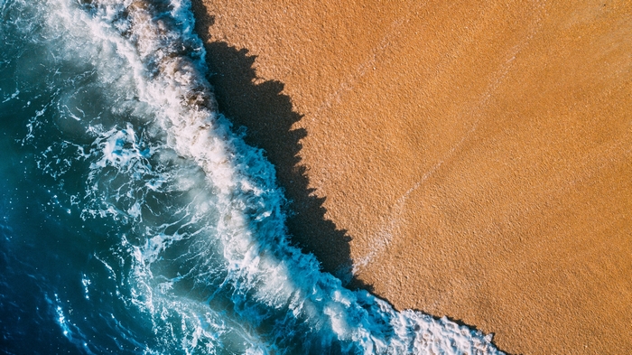 Ocean wave crashing on a sandy beach