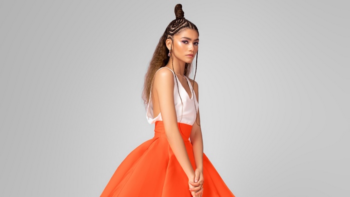 Zendaya in orange skirt and white top