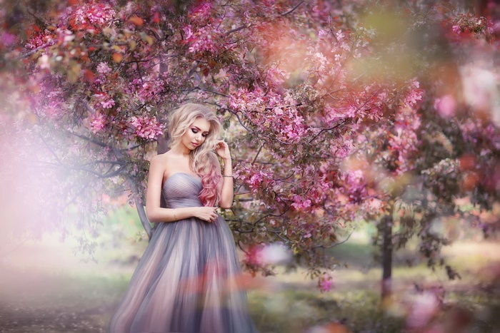 Woman in a dress under a blooming tree