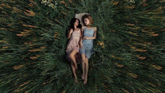 Two Women Lying in Green Grass with Dresses