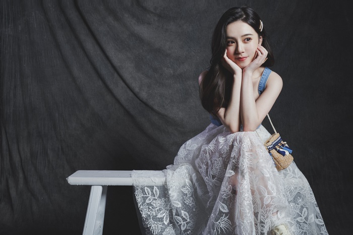 Asian woman with black hair sitting on a bench