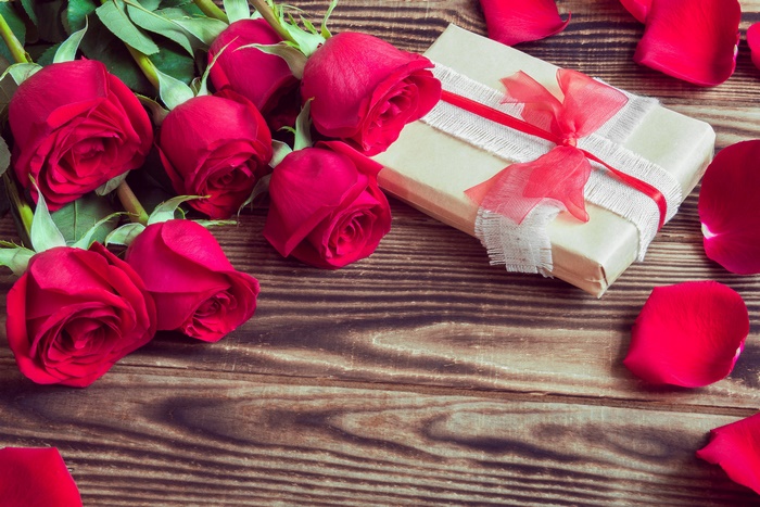 Red Roses and Gift on Wooden Table
