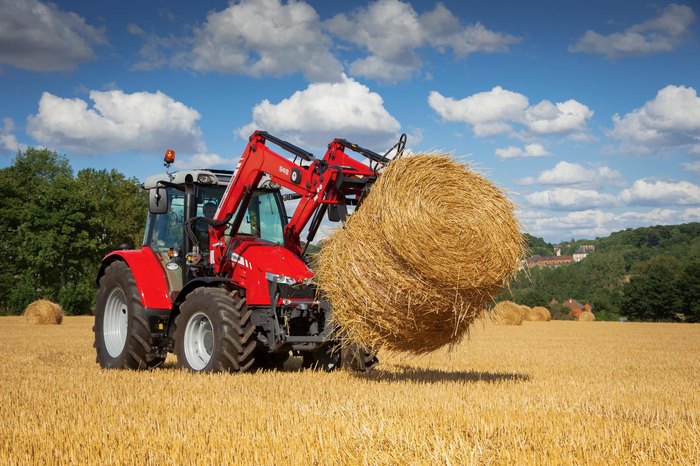 Massey Ferguson tractor loading hay bale