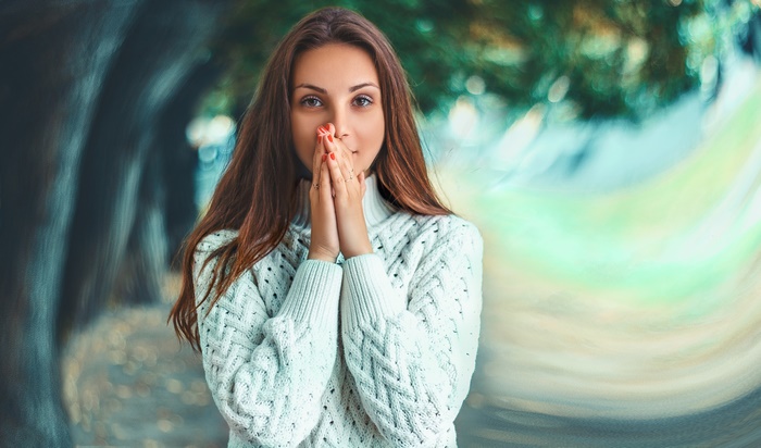 Woman with brown hair wearing a white sweater
