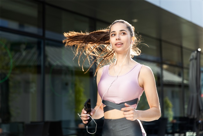 Brunette Woman Jogging with Phone and Earphones