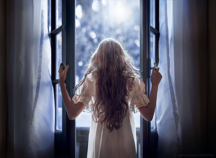 Girl in white dress opening a door