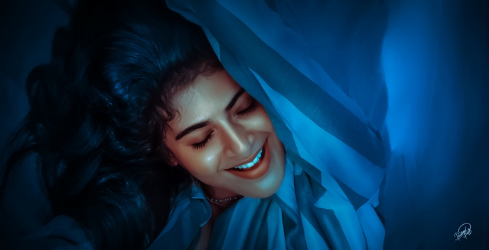 Iswarya Menon smiling under blue fabric