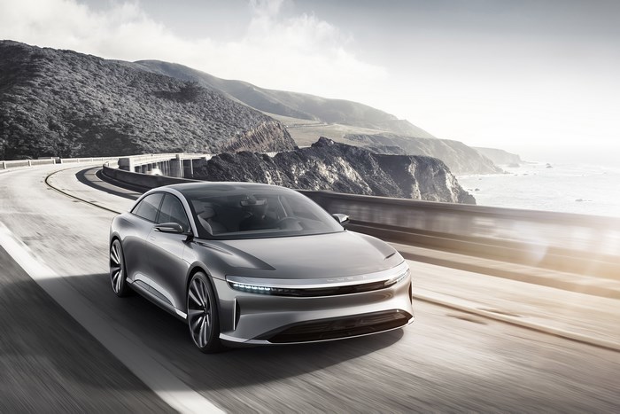 Silver Lucid Air Concept car driving on coastal highway