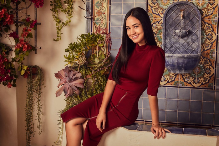 Woman in red dress with black hair smiling