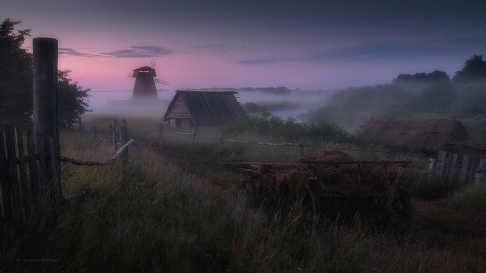 Rural landscape with windmill and fog at dawn