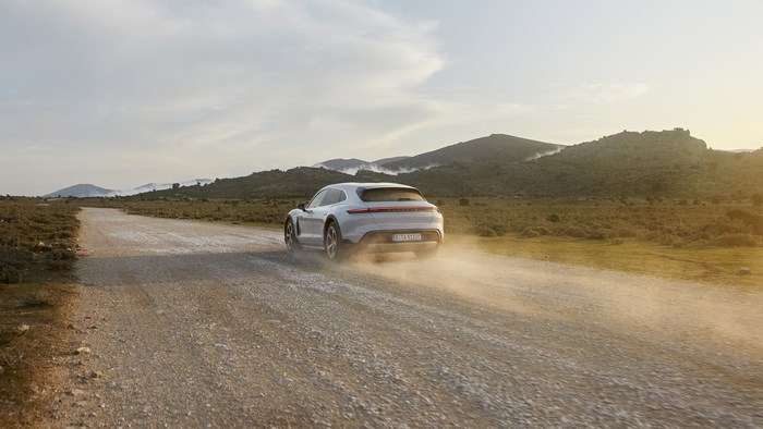 White Porsche Taycan 4S driving on a dirt road