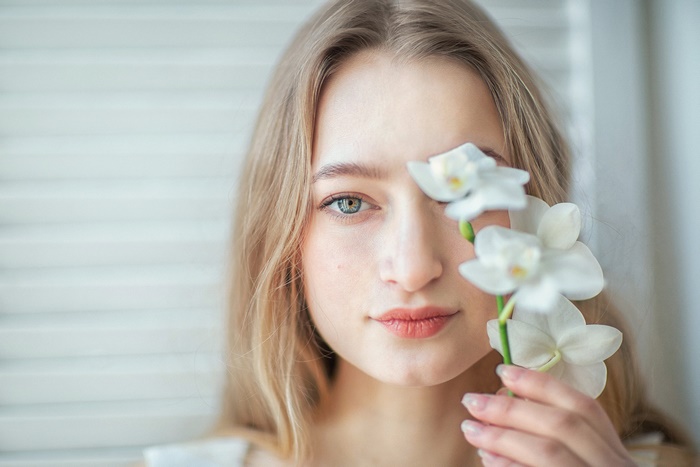 Woman with blonde hair holding white orchids