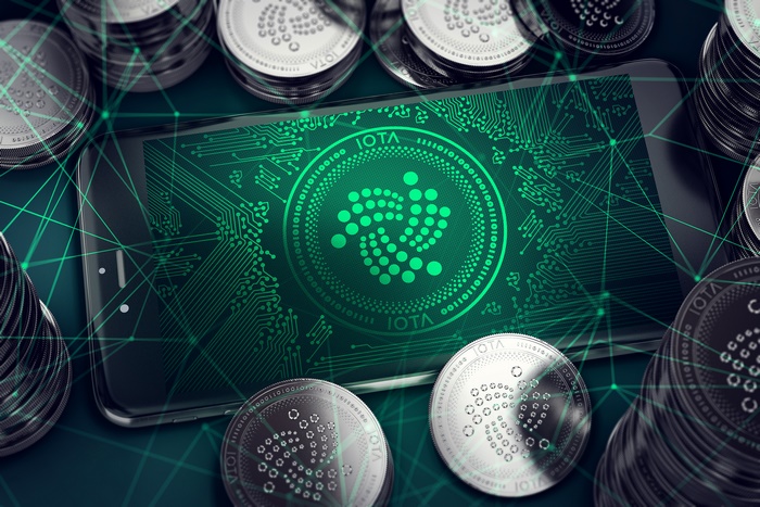 IOTA Cryptocurrency Logo on Smartphone Screen with Coins