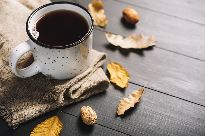 Still life with a cup of coffee and autumn leaves